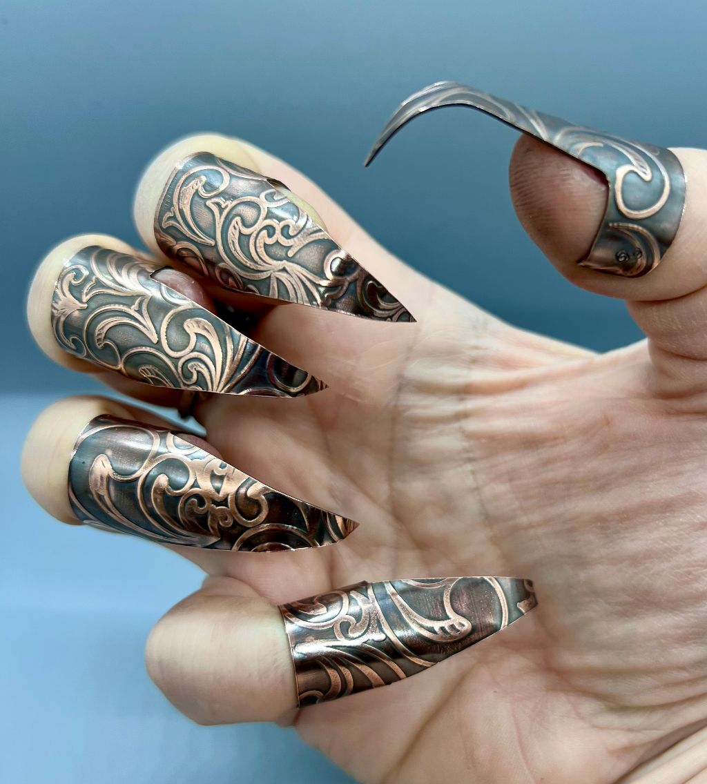 Copper claws with an Art Nouveau embossed texture, with black patina and polished highlights.