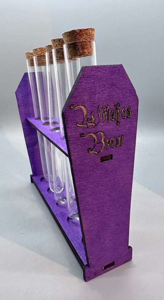 Purple coffin shaped potion rack with "Witches Brew" engraved and painted gold, with five test tubes with cork tops.