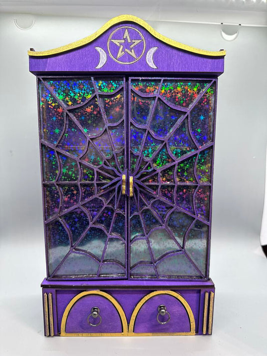 A very purple spiderweb door miniature cabinet with two drawers at the bottom.