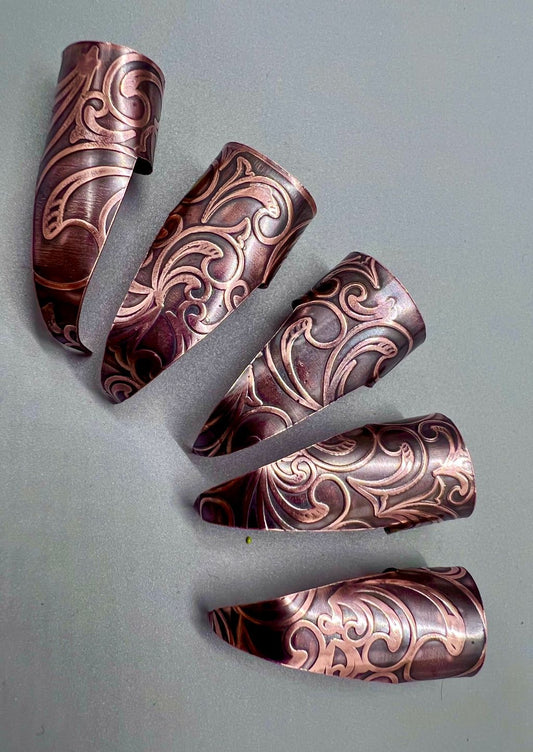 Copper claws with an Art Nouveau embossed texture, with black patina and polished highlights.