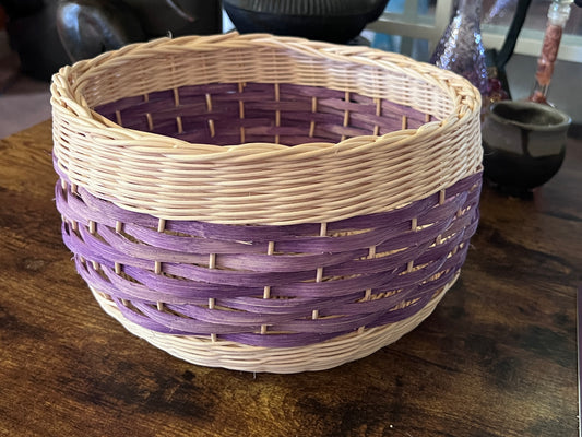 Woven reed basket in natural reed and purple dyed flat reed.