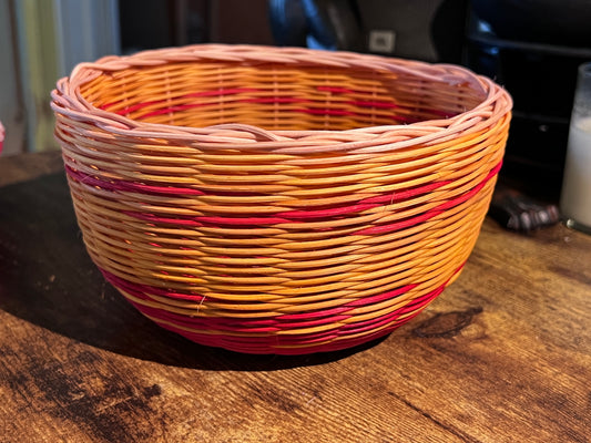 Red and yellow woven bowl with plain reed rim.