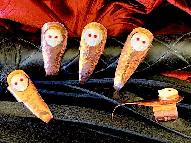 Hammered copper claws with bone skulls inset with red crystals, set of five.